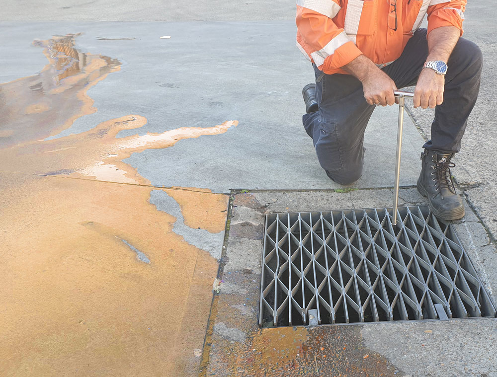 Man using the handle of the installed DrainSAFE stormwater isolation unit to close the valve and stop a chemical spill from leaving the storm water drain